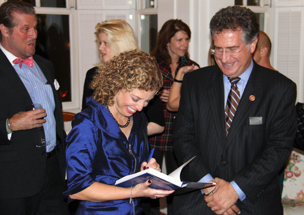 Rep. Debbie Wasserman Schultz signs a copy of her new book, For the Next Generation, for Rep. Joe Garcia at a book party held in her honor at Sen. Mary Landrieu's home.